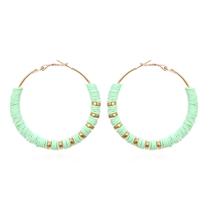 Macro detail of Bohemian large hoop earrings with mint green heishi beads and gold spacers