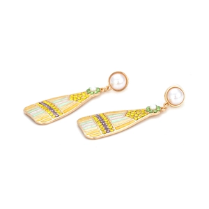 Close-up of golden alloy earring featuring colorful enamel stripes and inlaid rhinestones