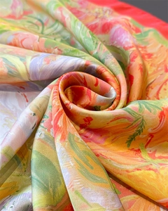 Detail shot of the abstract floral print and smooth silk texture on a colorful square scarf