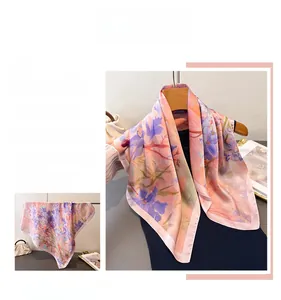 Dettaglio di sciarpa in seta a fiori rosa che mostra la consistenza liscia e il drappeggio