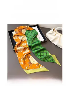 Close-up of double-sided silk scarf showing orange floral and green geometric patterns