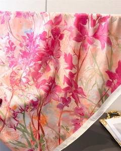 Dettaglio di foulard in seta a fiori rosa con bordi arrotolati e trama del tessuto fluido