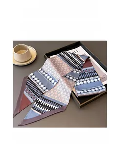 Detailed view of geometric pattern silk scarf folded in a minimalist tray setting