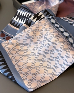 Detail of silk satin scarf showing geometric honeycomb patterns and soft draped texture