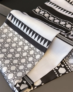 Detailed macro view of black and white geometric silk scarf with hexagonal honeycomb patterns