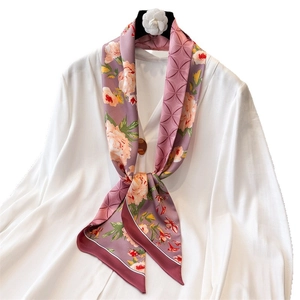Elegant lilac silk scarf with orange floral pattern tied on white shirt collar