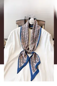 Detail of silk scarf with vintage chain patterns on a white suit jacket collar