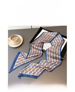 Close-up of vintage pattern silk scarf with navy borders on a white ceramic saucer