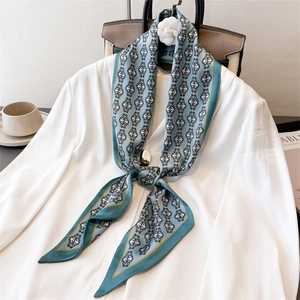 Elegant lake blue silk scarf with vintage pattern tied on a white office shirt