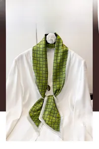 Détail du foulard en soie vintage à carreaux géométriques vert vif et noir élégant
