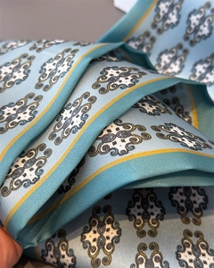 Detailed view of the sky blue vintage baroque pattern and smooth silk texture on the scarf