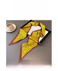 Détail d'un foulard en soie jaune avec motif de chaîne géométrique rétro et bordure marron