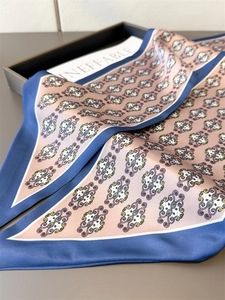 Detailed close-up showing silky fabric texture and vintage scroll patterns on the scarf