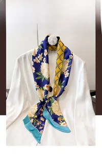 Dettaglio di foulard stretto in seta con fiori blu e motivi geometrici gialli