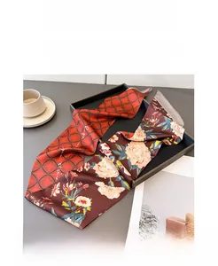 Dettaglio di un foulard twilly bifacciale con motivi geometrici rossi e floreali