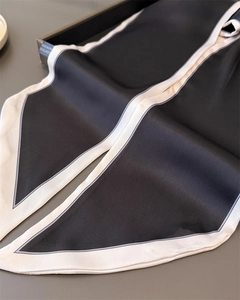 Detail of black and white silk scarf with satin finish and elegant pointed edge design