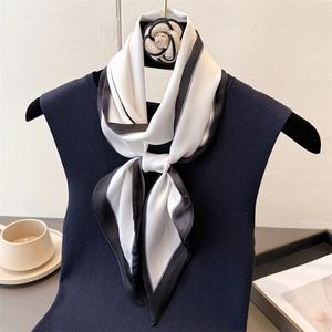 Minimalist black and white silk scarf tied on clothing for elegant office wear look