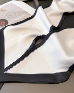 Detailed close-up showing the smooth silk texture and fine stitching of the bicolor scarf