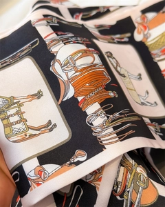 Dettaglio della stampa equestre e trama in seta twill in nero e caramello