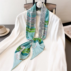 Elegant emerald chain print silk scarf styled with white shirt and luxury accessories