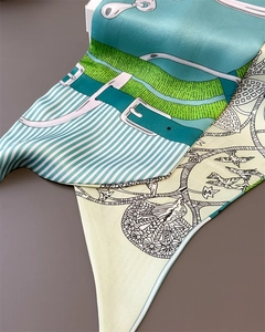 Macro detail of silk scarf texture showing horse harness patterns and bird motifs