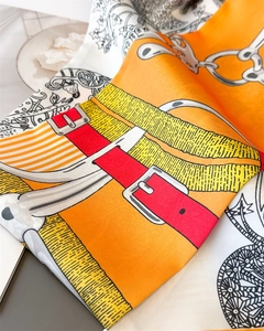 Detail of silk scarf showing vintage chain horse harness pattern and luxury fabric texture