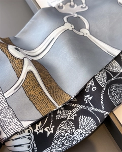 Macro detail of silk scarves featuring vintage horsebit patterns and botanical illustrations