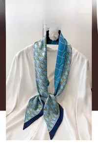 Detailed view of sky blue silk scarf with geometric letter patterns on white shirt