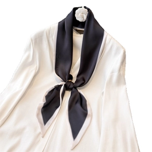 Elegant black and white contrast silk scarf styled with a white camellia flower brooch