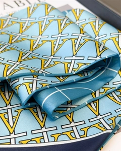 Close-up of sky blue silk scarf featuring geometric V-pattern and elegant texture
