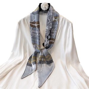 Vintage chain print silk scarf in blue and gold tied on a white dress shirt collar