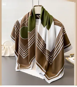 Detail of silk-feel scarf with geometric patterns in caramel and olive green hanging