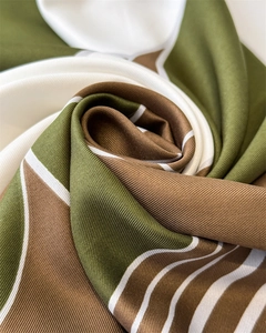 Macro detail of geometric silk scarf with green and brown stripes in premium twill weave