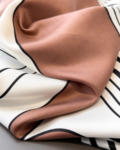 Macro view of twill texture and geometric pattern on soft silk-like fabric scarf