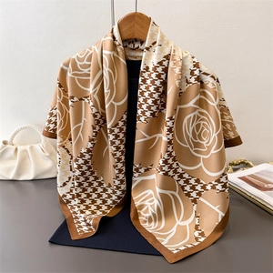 Elegant houndstooth silk scarf with floral print styled on a wooden hanger with a handbag