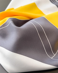 Macro shot of geometric block pattern on soft satin scarf with fine twill texture