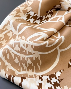 Close-up of houndstooth silk scarf showing premium diagonal weave texture and drape