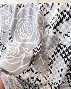 Detail of silk satin scarf featuring houndstooth pattern and large rose flower print