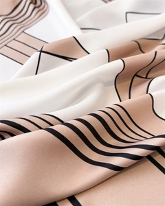Macro shot of geometric pattern scarf showing twill texture and silky draped fabric