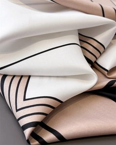 Detail of elegant geometric silk scarf featuring premium twill weave and neutral tones