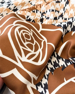 Detail of silk satin scarf showing houndstooth pattern and rose floral print fabric