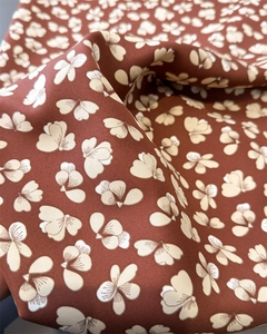 Nahaufnahme von Seidenschal mit Blumenmuster zeigt weichen Fall und Köperbindung