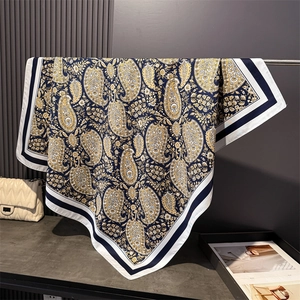 Vintage navy and yellow paisley silk-like square scarf draped on a metal stand