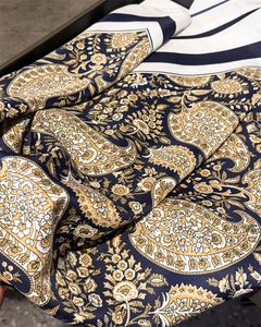 Detail shot of vintage paisley pattern on silky scarf with elegant draped folds