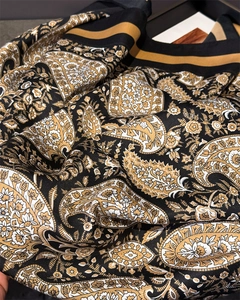 Macro detail of silk-like satin scarf featuring vintage paisley and floral patterns