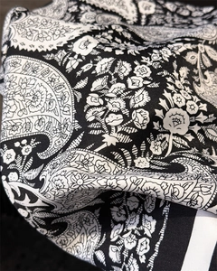 Close-up of black and white paisley silk scarf showing fine texture and floral patterns