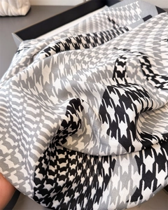 Close-up of houndstooth silk scarf showing premium texture and classic print detail