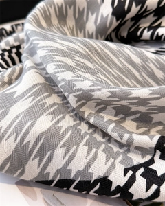 Detailed macro view of houndstooth pattern and geometric color blocks on silk scarf