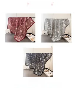Gros plan détaillé de foulards en soie à motif camélia en rouge, gris et noir