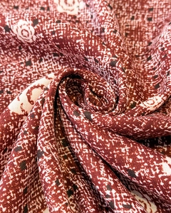 Macro du tissu aspect soie rouge foncé à imprimé camélia et texture tissée à chevrons
